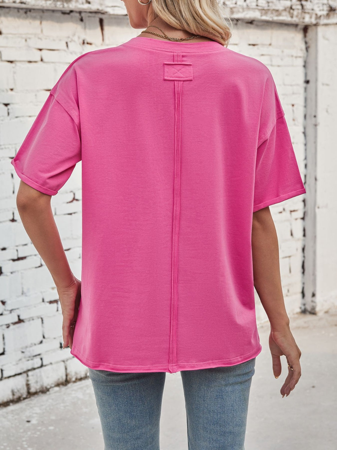 Oversized hot pink cotton tee with seam detail and rolled sleeves.