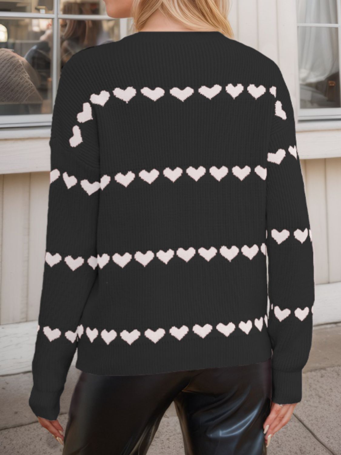 Black knit sweater with white heart stripes, long sleeves, crew neck.