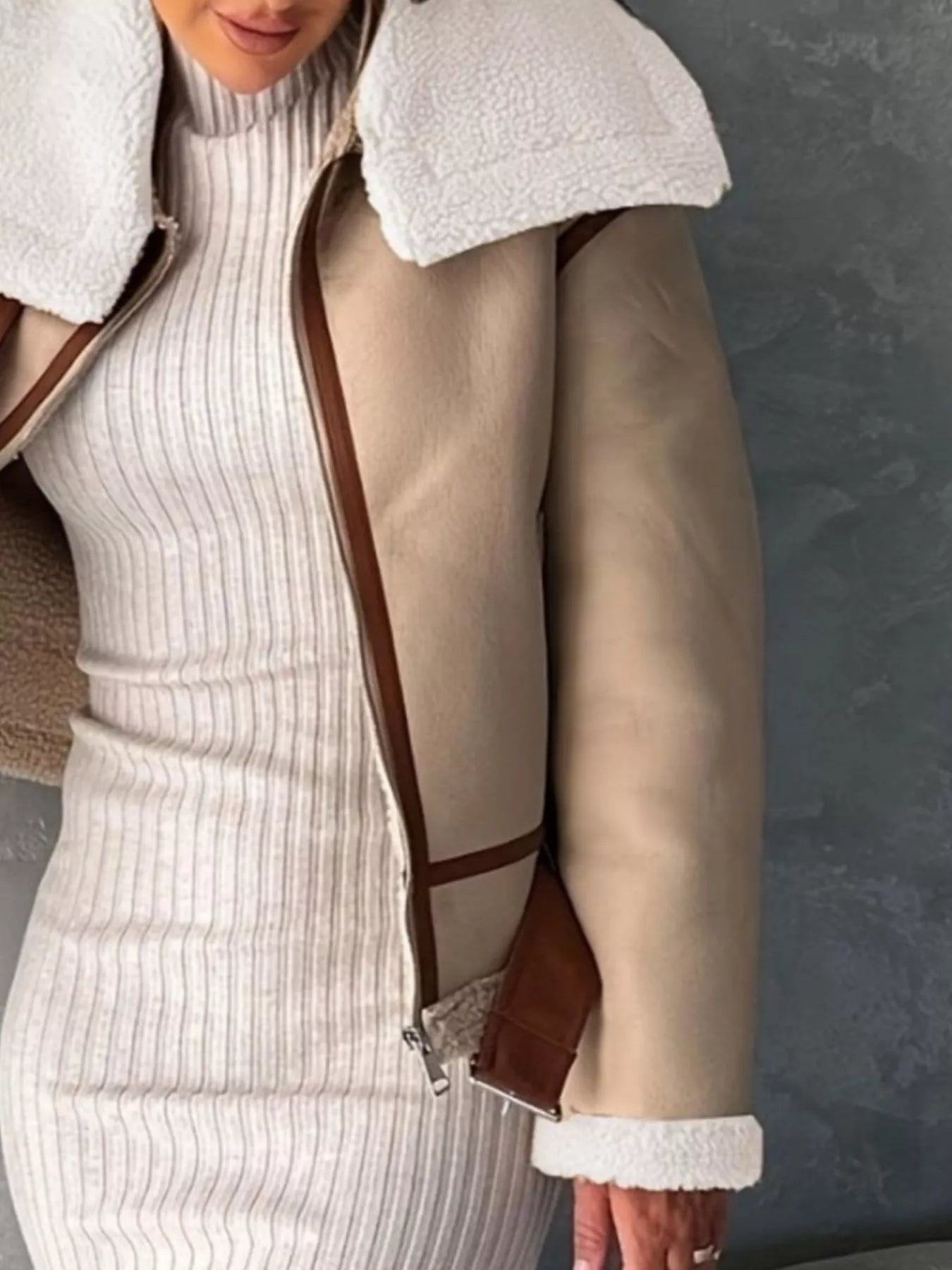 Shearling lined zip up jacket in brown with white trim and brown faux leather accents.