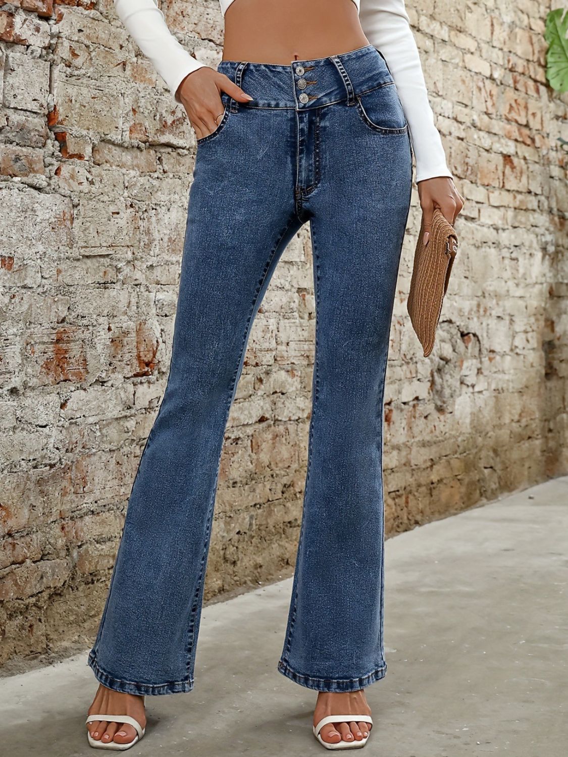 Medium wash cotton bootcut jeans with a sculpted waist and button fly.