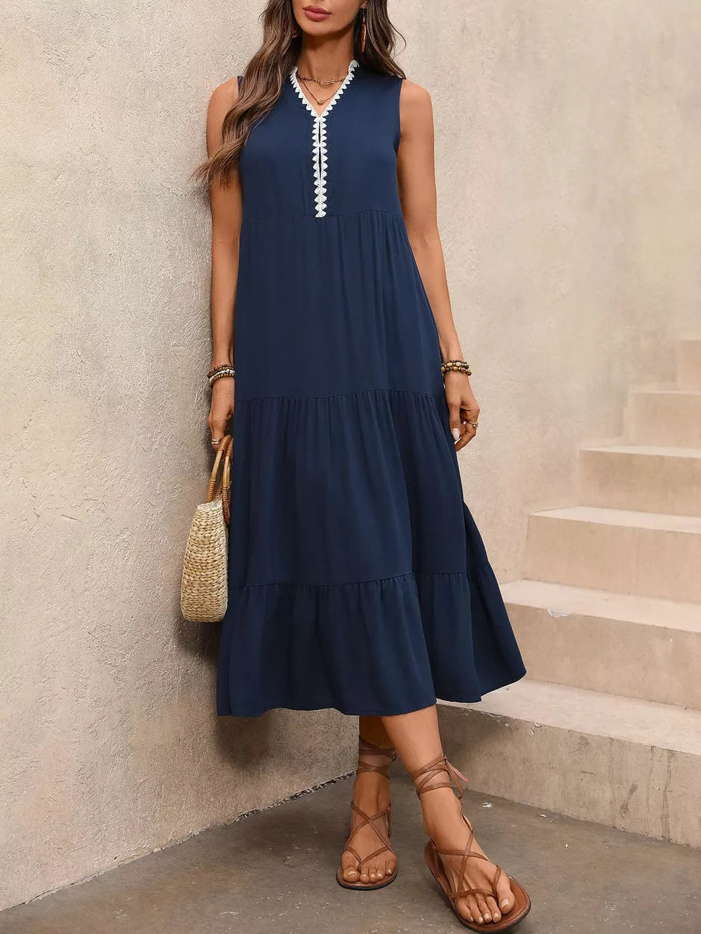 Navy midi dress with ruffled hem and white trim neckline, sleeveless, tiered skirt.