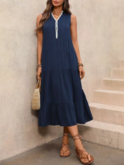 Navy midi dress with ruffled hem and white trim neckline, sleeveless, tiered skirt.
