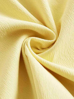 Light yellow cami dress fabric detail with crinkled texture.