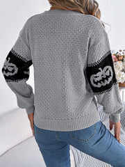 Gray knit sweater with jack-o'-lantern intarsia on sleeves.