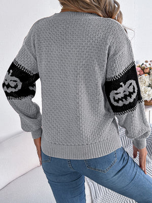 Gray knit sweater with jack-o'-lantern intarsia on sleeves.