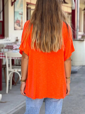 Orange-red relaxed fit tee with short sleeves and a V-neck, made of polyester.