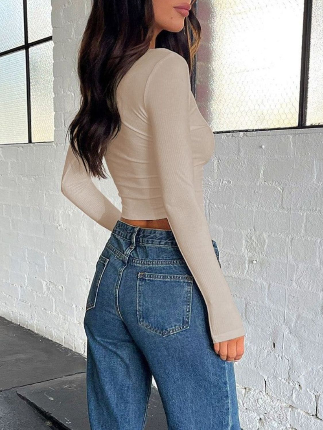 Sculpted ribbed V-neck crop top in beige with long sleeves.