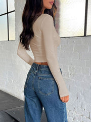 Sculpted ribbed V-neck crop top in beige with long sleeves.