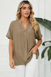 Camel textured blouse with V-neck, rolled short sleeves, and gathered back yoke detail.
