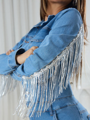 Medium wash denim jumpsuit with sequin fringe detail on sleeves and shoulders.