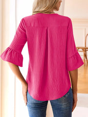 Pink maternity shirt with 3/4 bell sleeves and textured fabric.