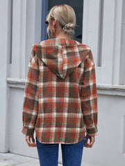 Plaid hooded shacket in rust, green, and white, relaxed fit, buttoned front detail.