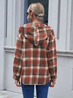 Plaid hooded shacket in rust, green, and white, relaxed fit, buttoned front detail.