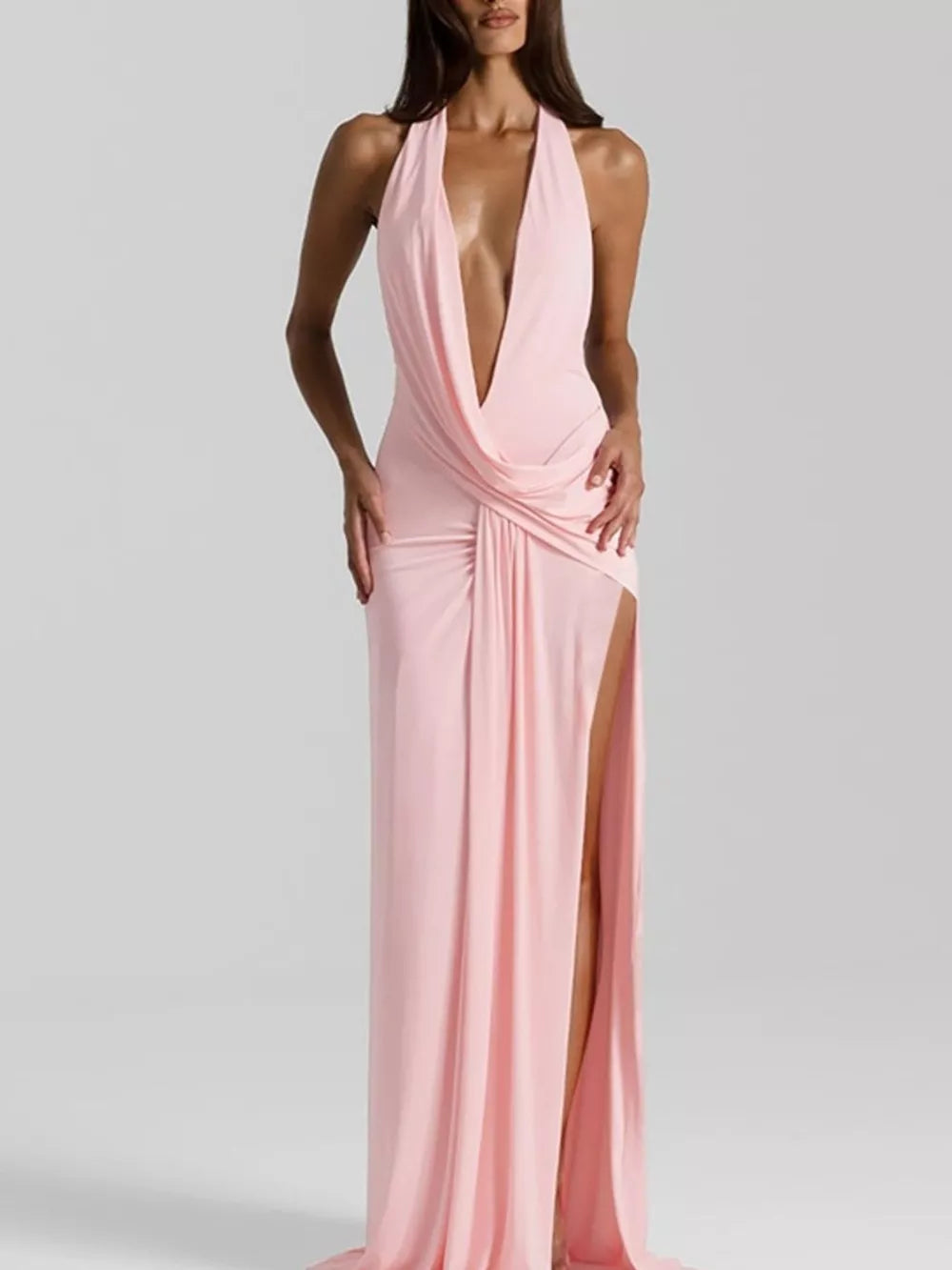 Pink ruched halter neck maxi dress with deep V-neck and high slit.