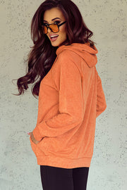 Textured coral hoodie with raglan sleeves and front pocket detail.