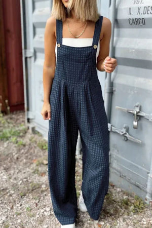 Textured dark blue wide-leg overalls with button detail and a checkered pattern.