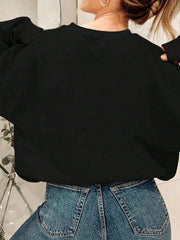 Black crewneck sweatshirt with ribbed cuffs and hem, styled with denim jeans.