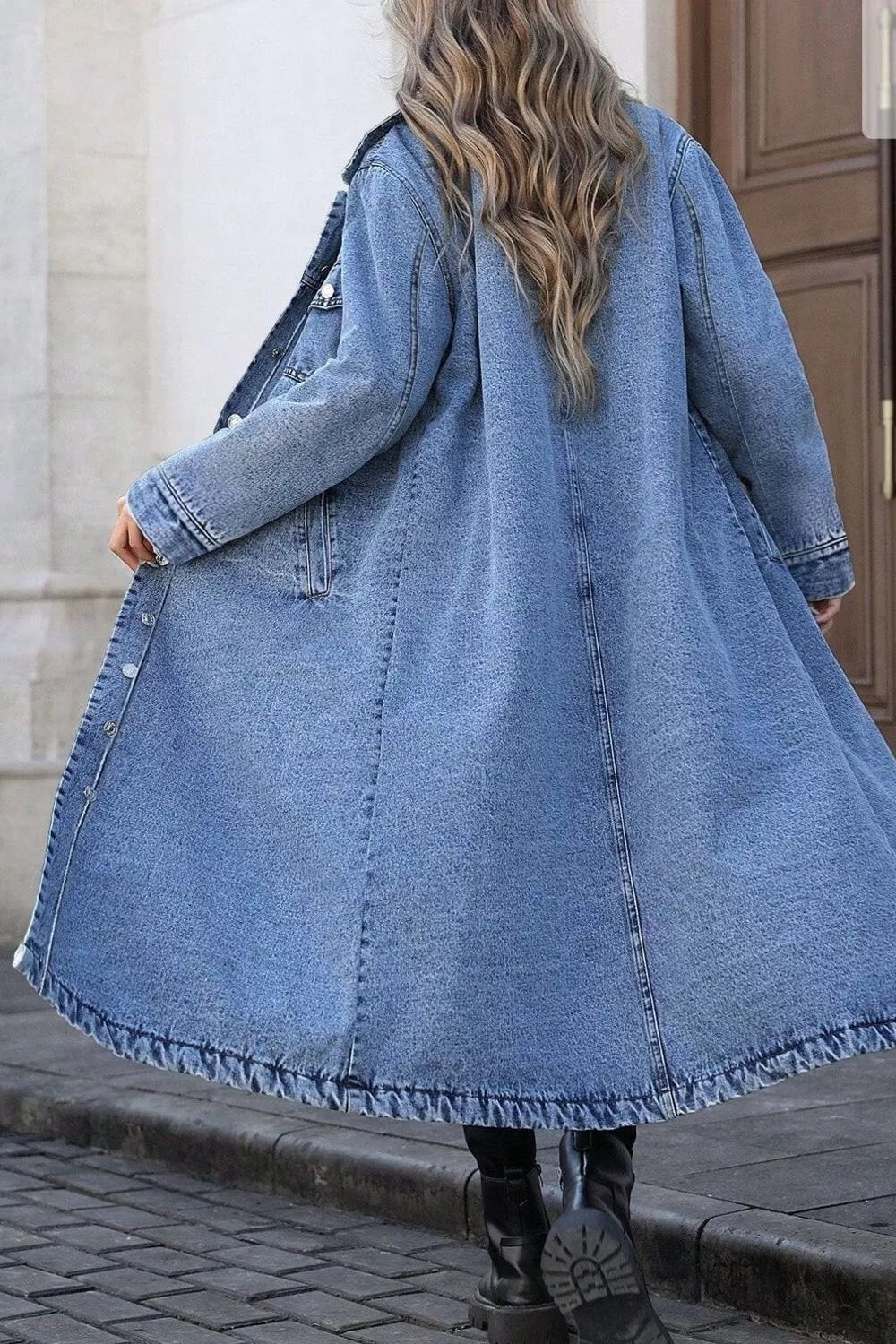 Longline blue denim jacket with pockets and a frayed hem, worn open.