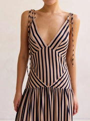 Tie-shoulder maxi dress with V-neck in navy and tan stripes, featuring adjustable tie straps and a tiered skirt.