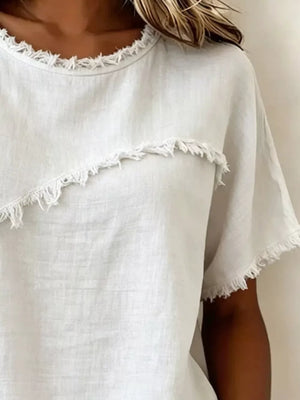 White crew neck short sleeve shirt with frayed hem detail and asymmetrical accent.