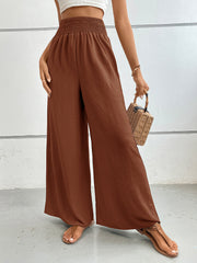 Textured palazzo lounge trousers in rust with a smocked waistband and wide legs.