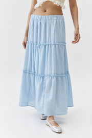 Tiered cotton maxi skirt in light blue with elastic waistband and ruffled tiers.