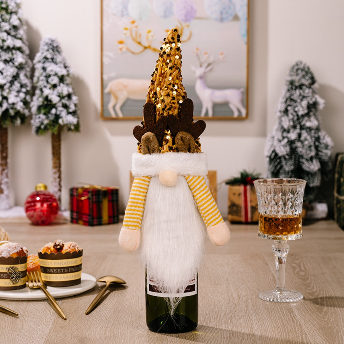 Festive gnome bottle topper with gold sequin hat and antlers, white beard, yellow striped sleeves.