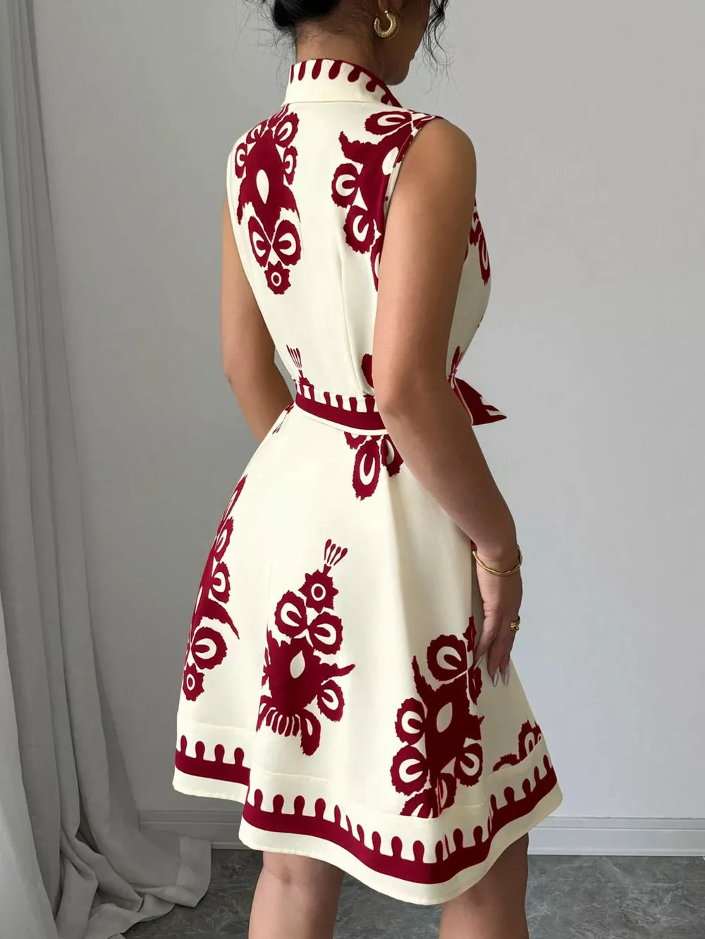 Cream sleeveless a-line dress with burgundy print and tie waist