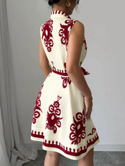 Cream sleeveless a-line dress with burgundy print and tie waist