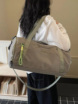 Large dark gray nylon travel duffle bag with green accents and zipper detail.