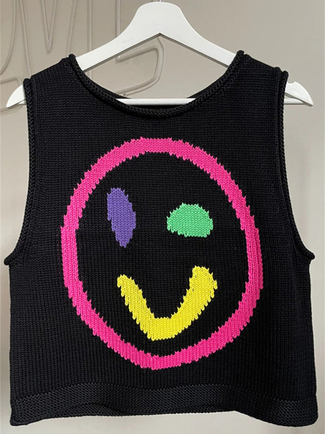 Black knit tank top with a colorful smiley face graphic and pink trim.