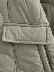 Lined quilted button-down jacket in moss green with a patch pocket and white contrast stitching.