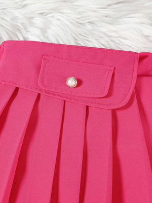 Pink baby skirt with pleated detail and decorative button on pocket.