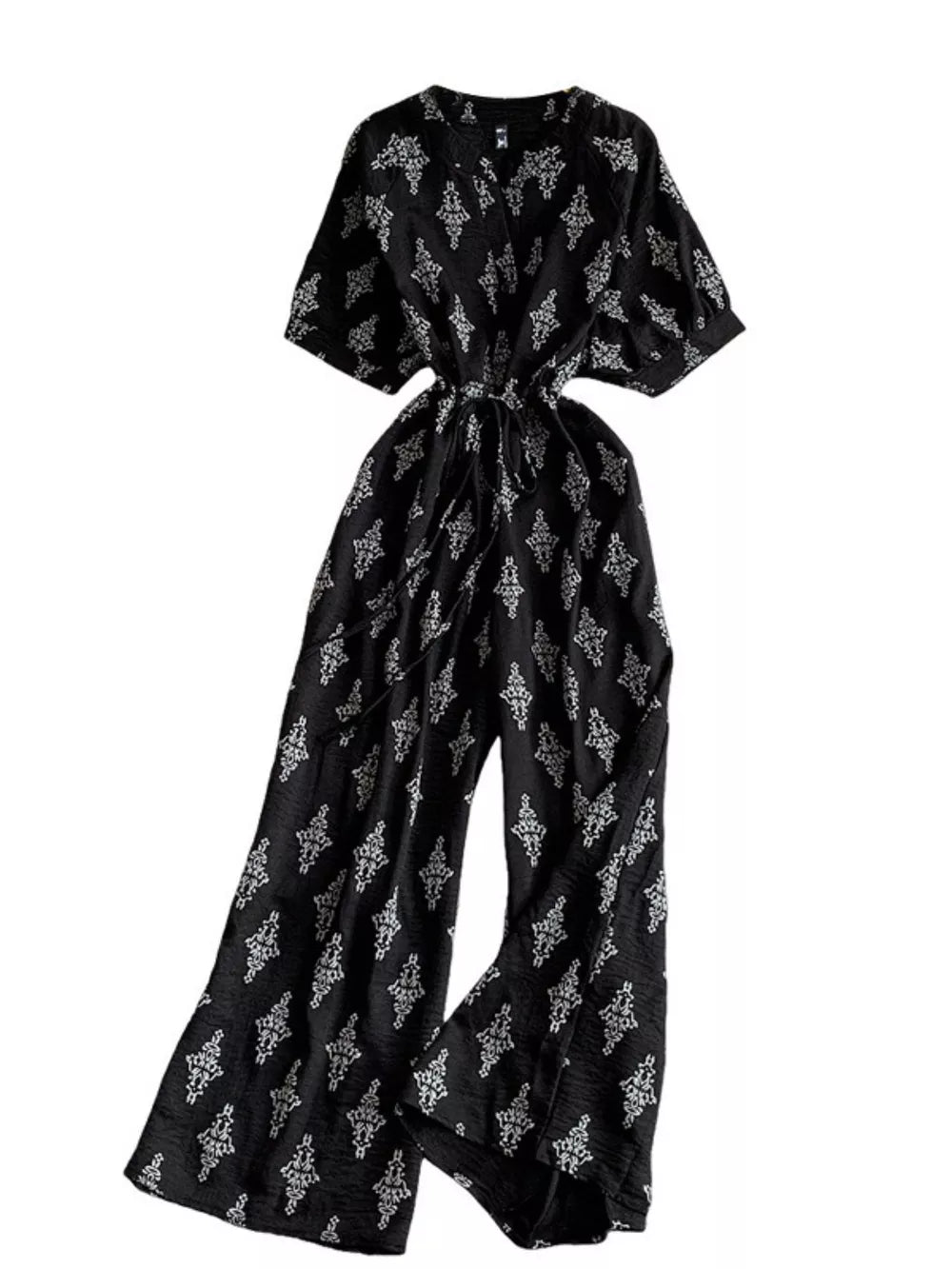 Black patterned jumpsuit with drawstring waist and wide legs.
