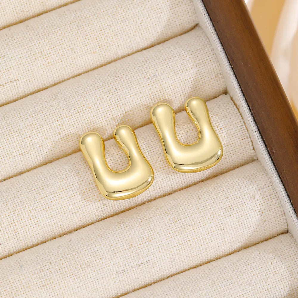 Gold sculpted alphabet earrings in a bubble style, copper material.