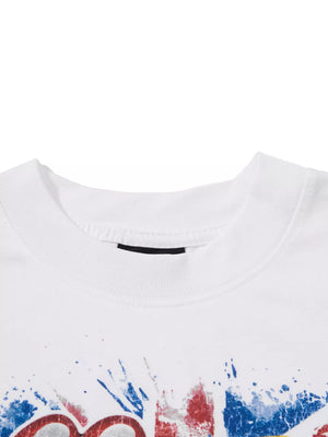 White cotton t-shirt with red, white, and blue graphic print and splatter details.