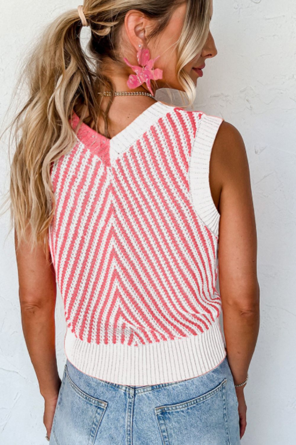 Chevron knit vest in coral and white with a V-neck and ribbed hem.