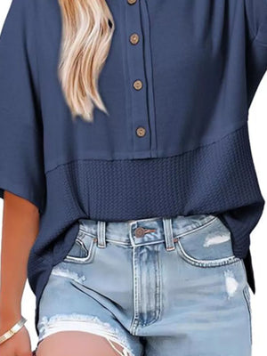 Blue waffle-knit t-shirt with button detail and textured hem.