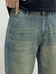 Men's loose-fit blue-green washed cotton jeans with vintage detailing.