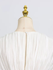 White pleated mini dress with balloon sleeves, showing back zipper detail