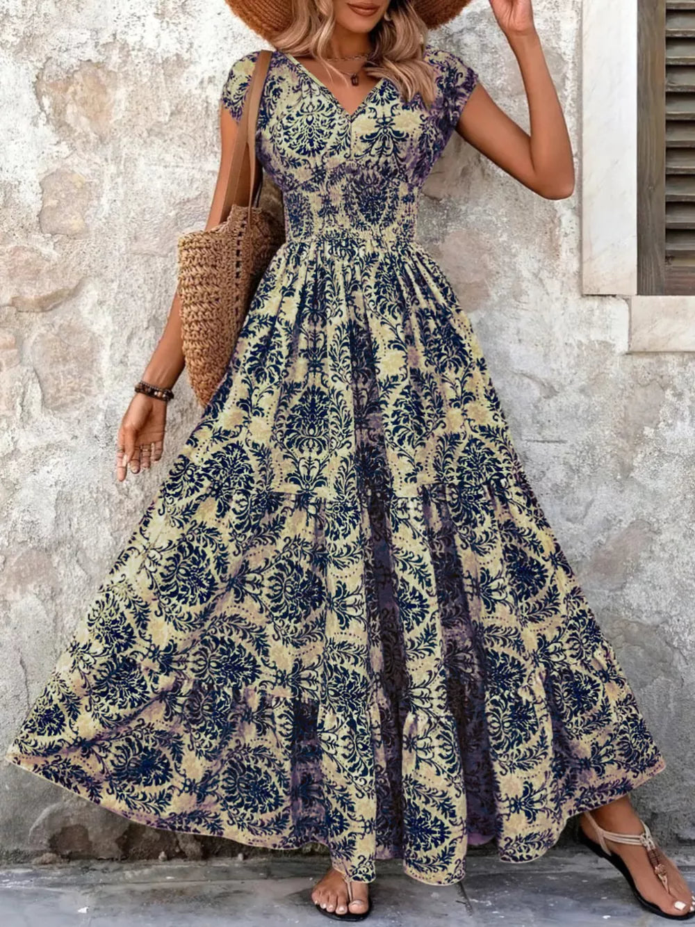 Maxi dress with smocked bodice, v-neck, short sleeves, and tiered skirt in a dark blue floral pattern.