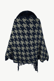 Houndstooth poncho with faux fur collar and fringe trim in dark blue and beige.