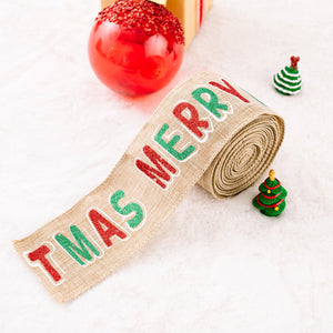 Burlap ribbon with red and green glitter "MERRY CHRISTMAS" text, rolled on a spool.
