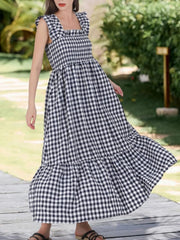 Black gingham midi dress with ruffled square neck and sleeves, smocked bodice, tiered skirt.
