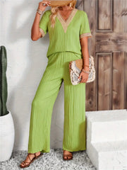 Lime crinkle knit v-neck co-ord set with crochet trim, wide leg pants, and short sleeves.