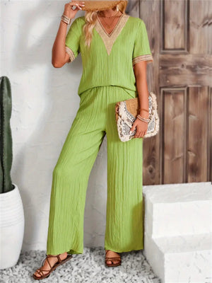 Lime crinkle knit v-neck co-ord set with crochet trim, wide leg pants, and short sleeves.