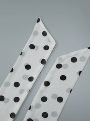 White and black polka dot mini dress with halter neck and ruched detail.