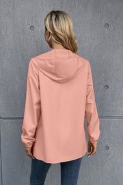Blush pink hooded rain coat with long sleeves and elastic cuffs.