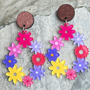 Floral wreath dangle earrings with colorful acrylic flowers and wooden tops.