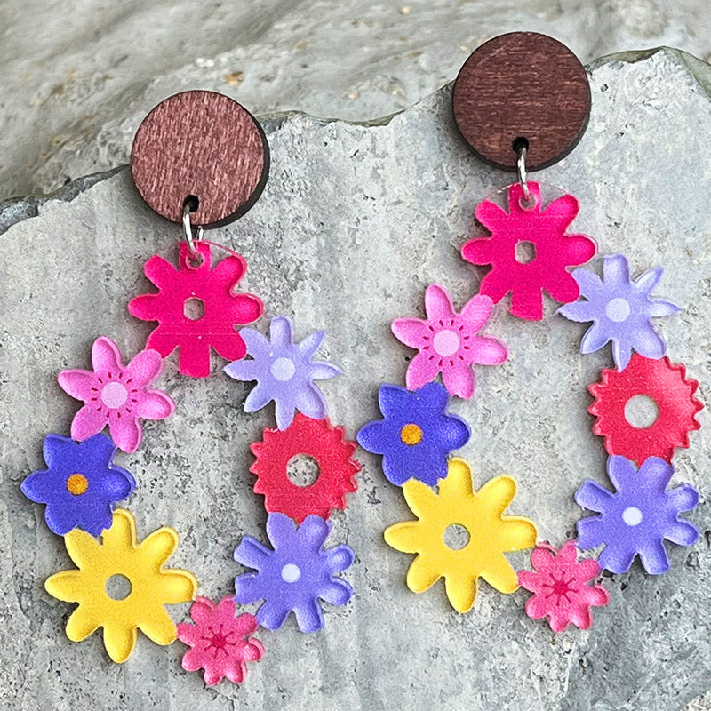 Floral wreath dangle earrings with colorful acrylic flowers and wooden tops.